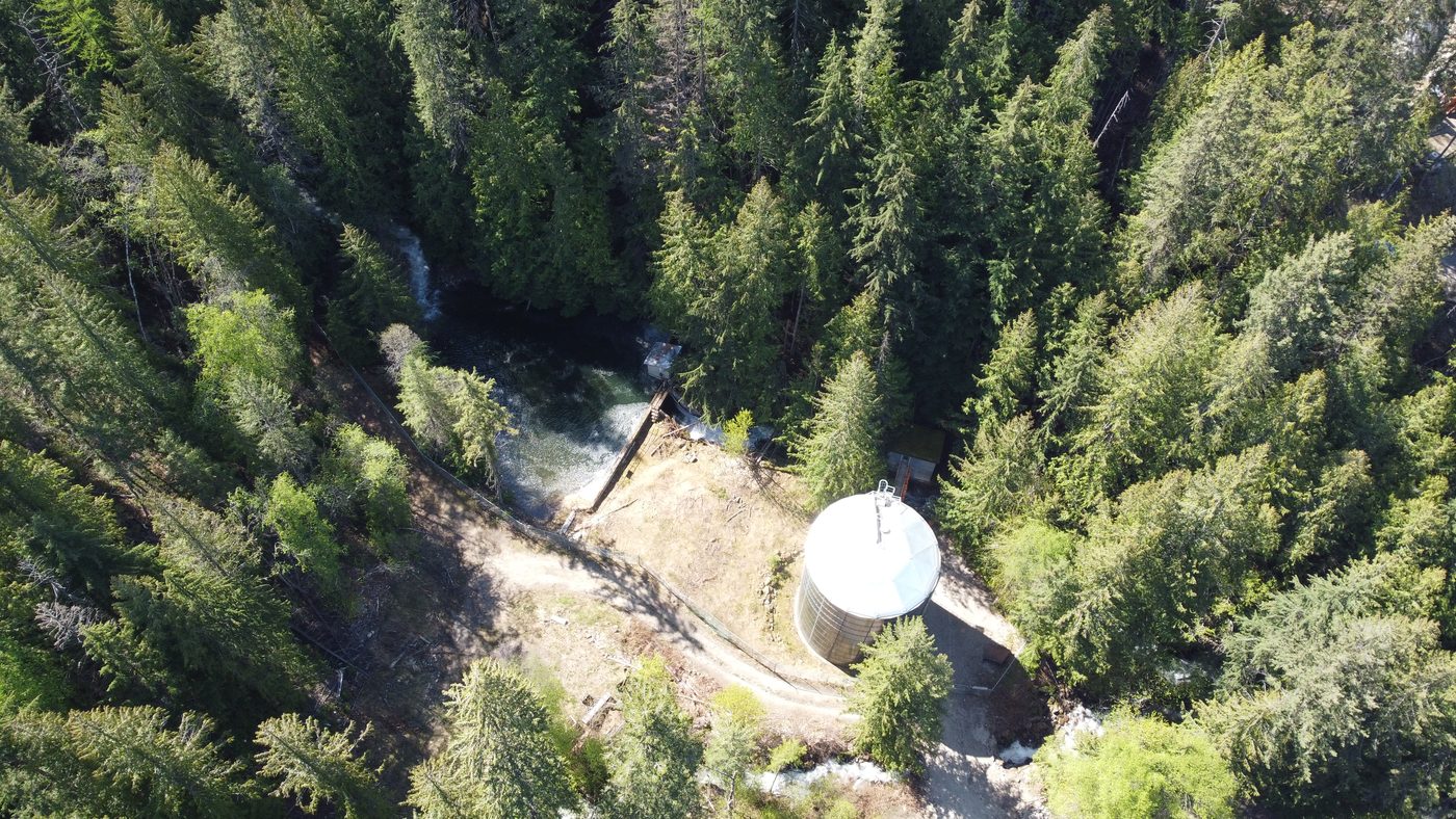 Aerial view of a creek intake and water tank in the forest